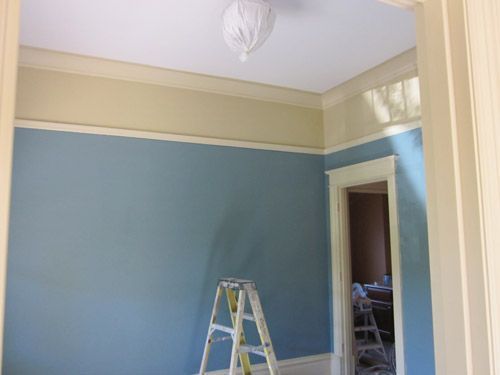 A room with blue walls and a ladder in it.