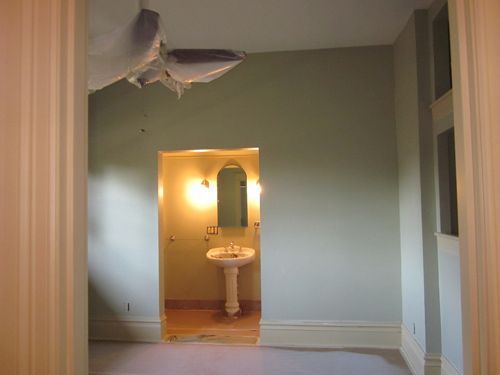 A bathroom with a sink and a fish hanging from the ceiling.