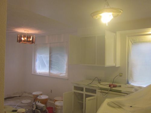 A kitchen with white cabinets and a light hanging from the ceiling.