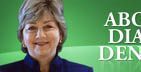 Woman smiling in front of green background with