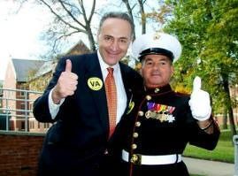 Man in suit and Marine in uniform giving thumbs up. VA logo visible. Outdoors, daytime.