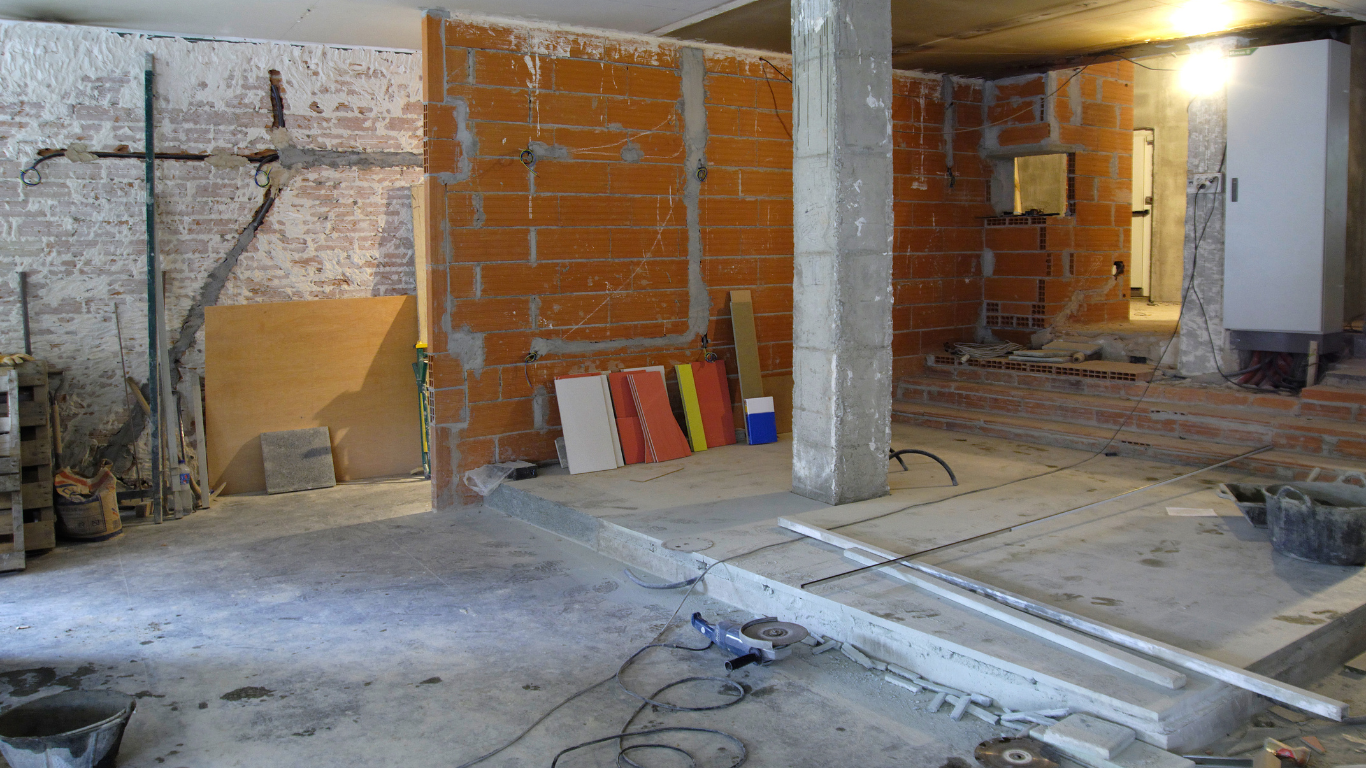 A room under interior demolition with brick walls and a cross on the wall.