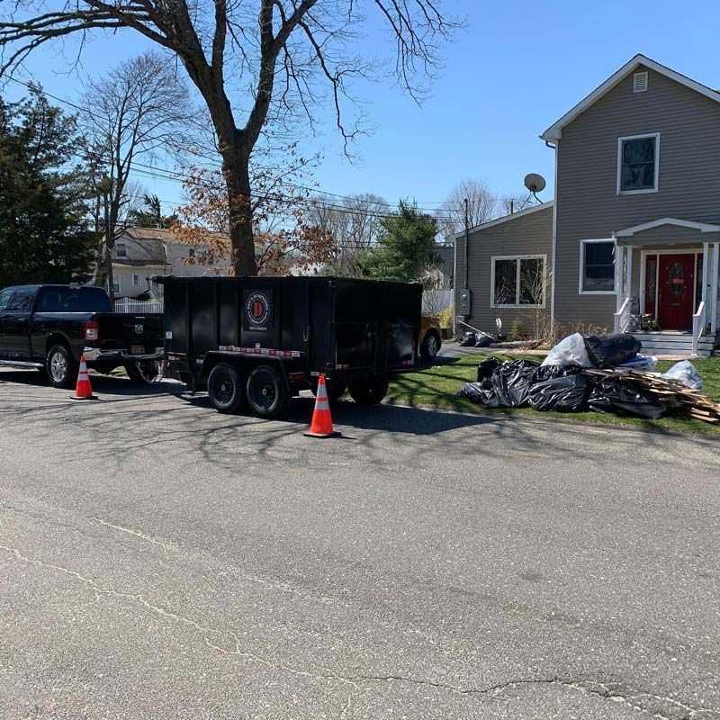 A dumpster is parked in front of a house - junk removal