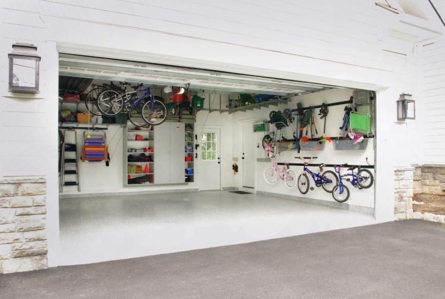 A white garage with bikes hanging from the ceiling and shelves. - dons demolition