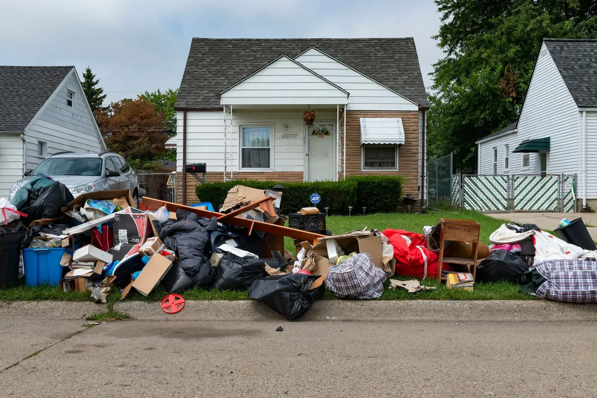 A pile of trash is sitting on the side of the road in front of a house. - dons demolition