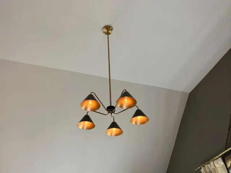 Five-light pendant chandelier with orange shades on a white ceiling