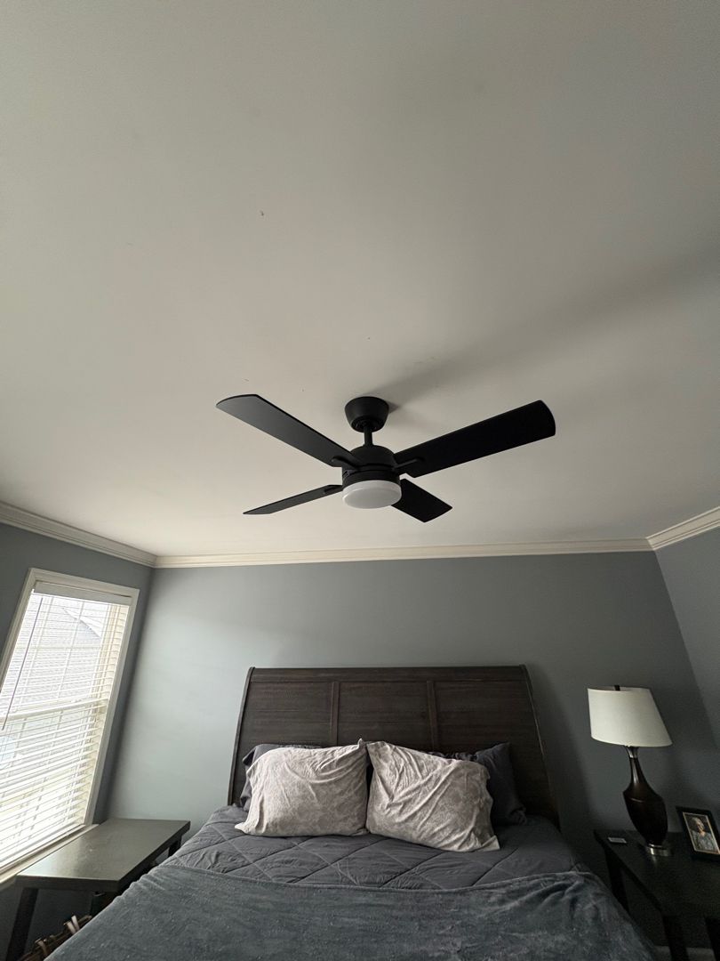 Bedroom with gray walls, dark wood bed, black ceiling fan, and a window with blinds on the left.
