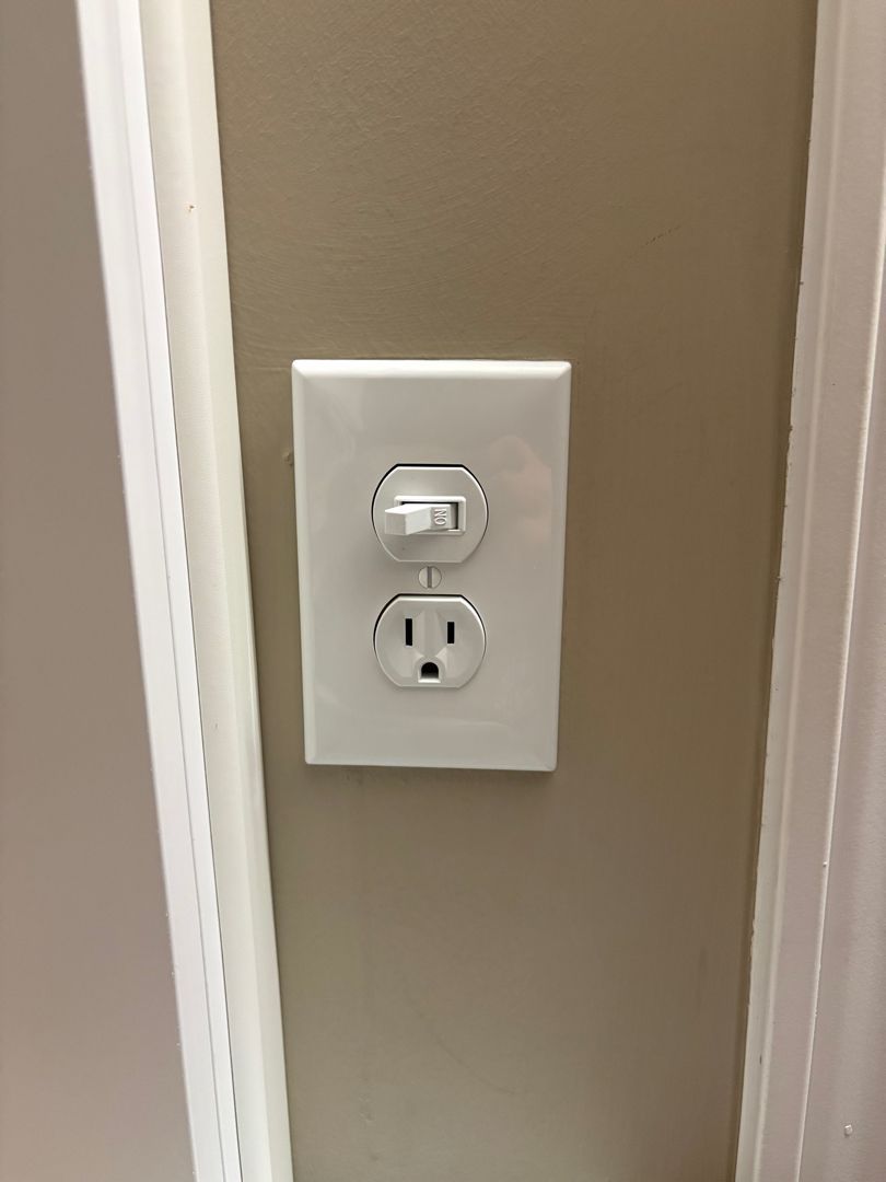 White wall outlet with a night light and a standard electrical socket on a beige wall.
