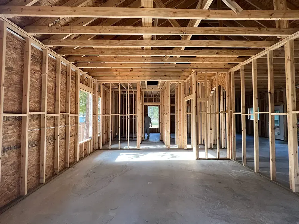 Interior of a building under construction, wooden framework with open walls and ceiling.