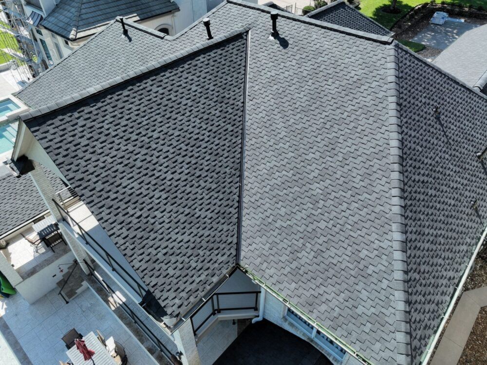 Overhead view of a house with a dark gray shingle roof.