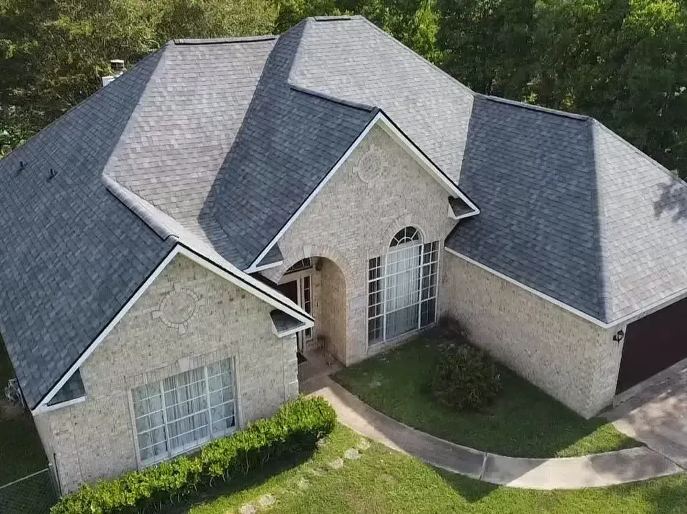 House with gray roof, brick exterior, and arched window.