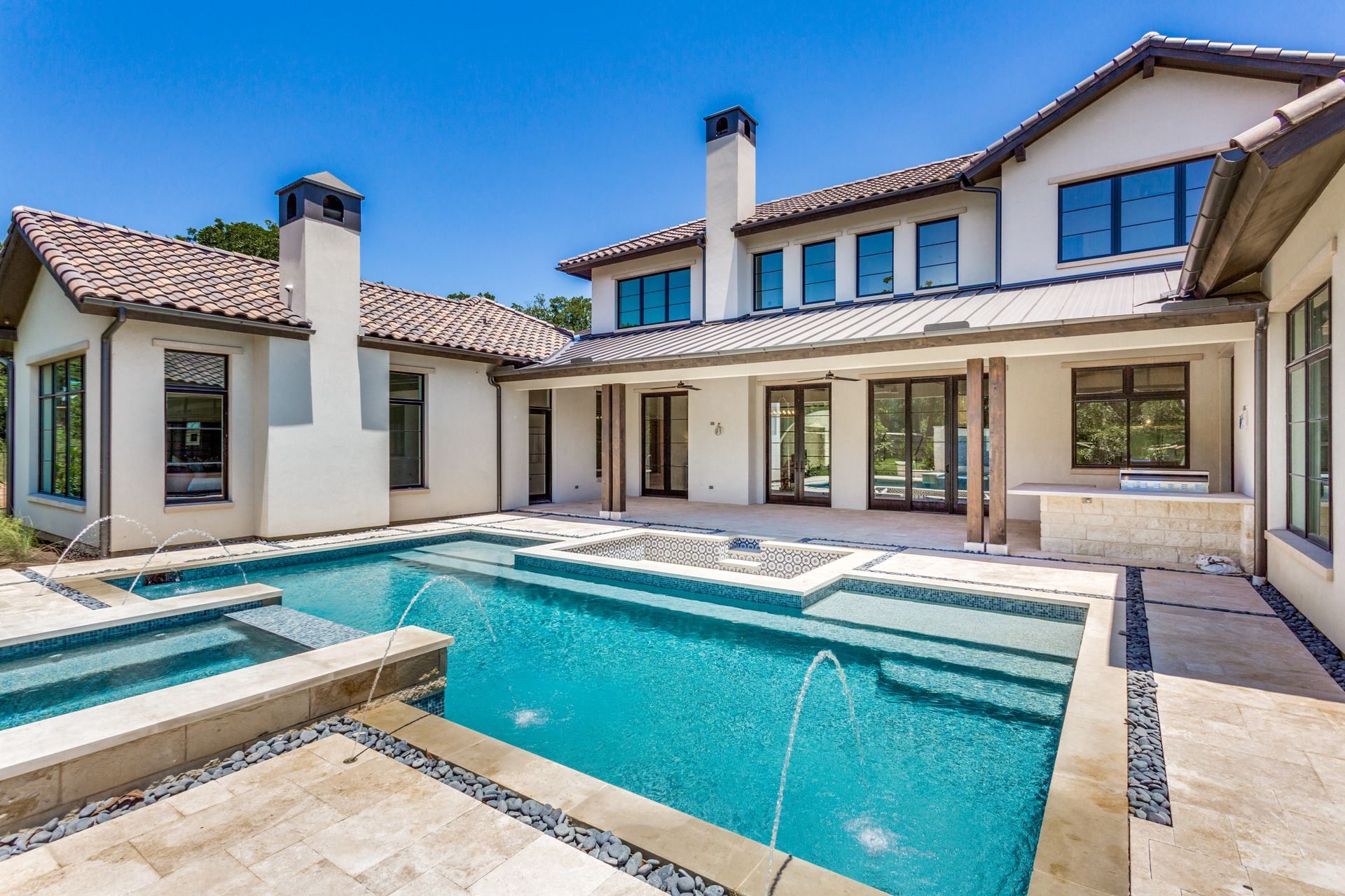 A modern, luxurious house with a swimming pool in the foreground.