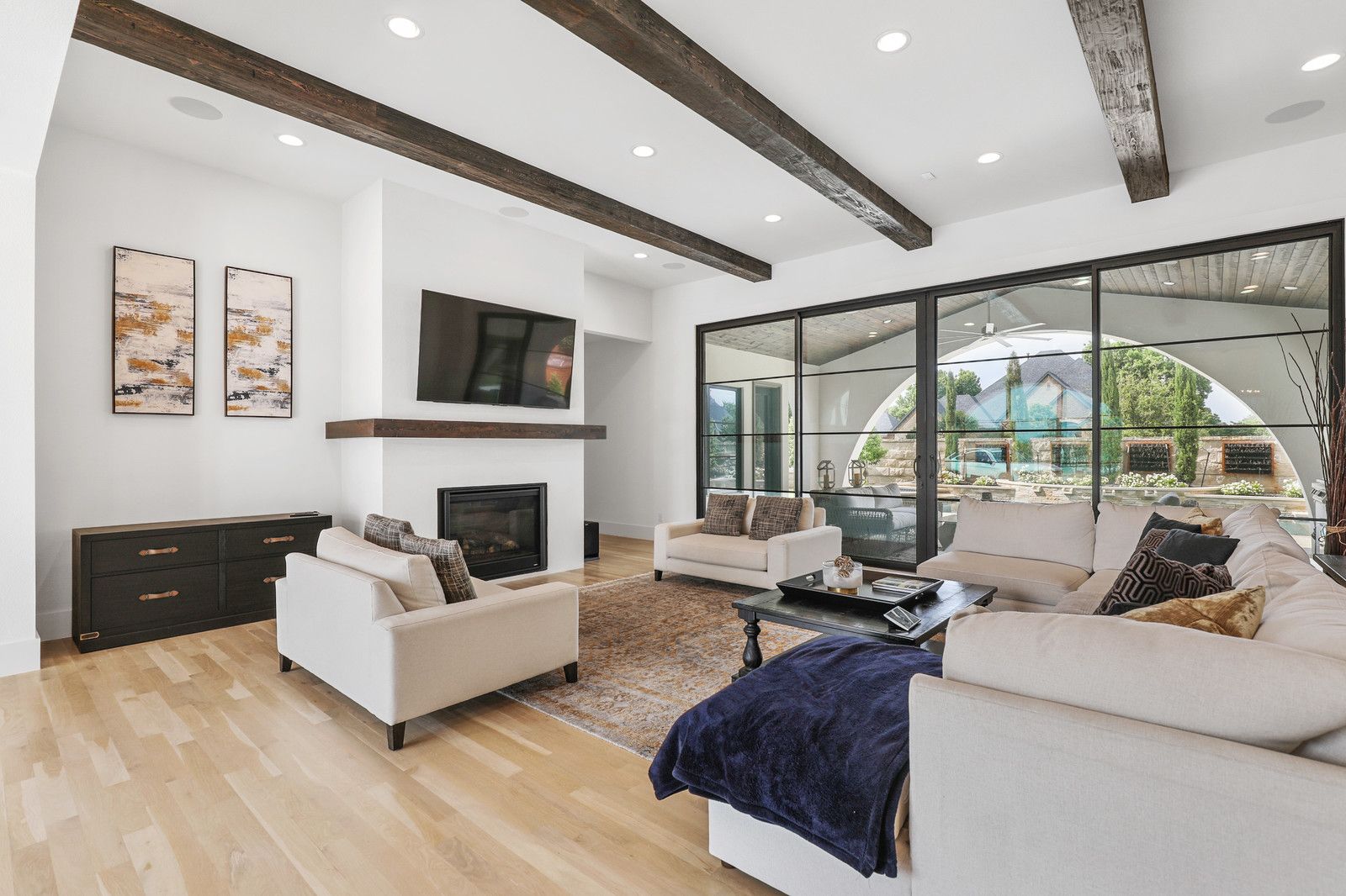  A bright and inviting living room with large windows and a view of the outdoor pool area.