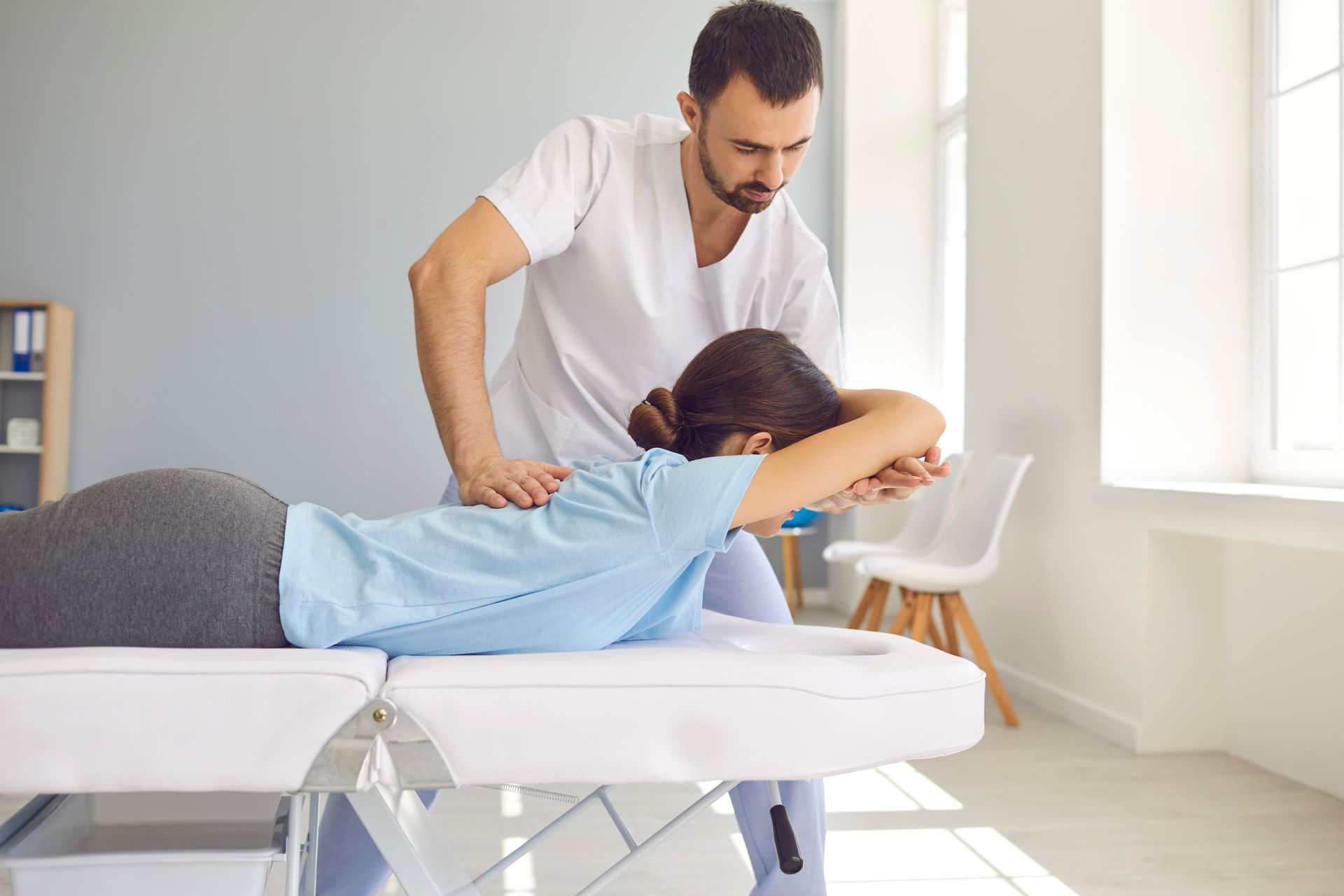 A man is giving a woman a massage on a table.