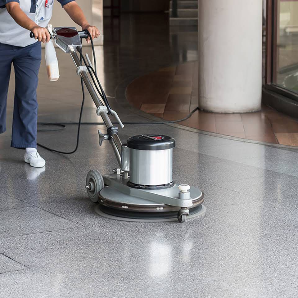 A Man Is Using a Machine to Clean a Floor — North Coast Commercial Cleaners In Maroochydore, QLD