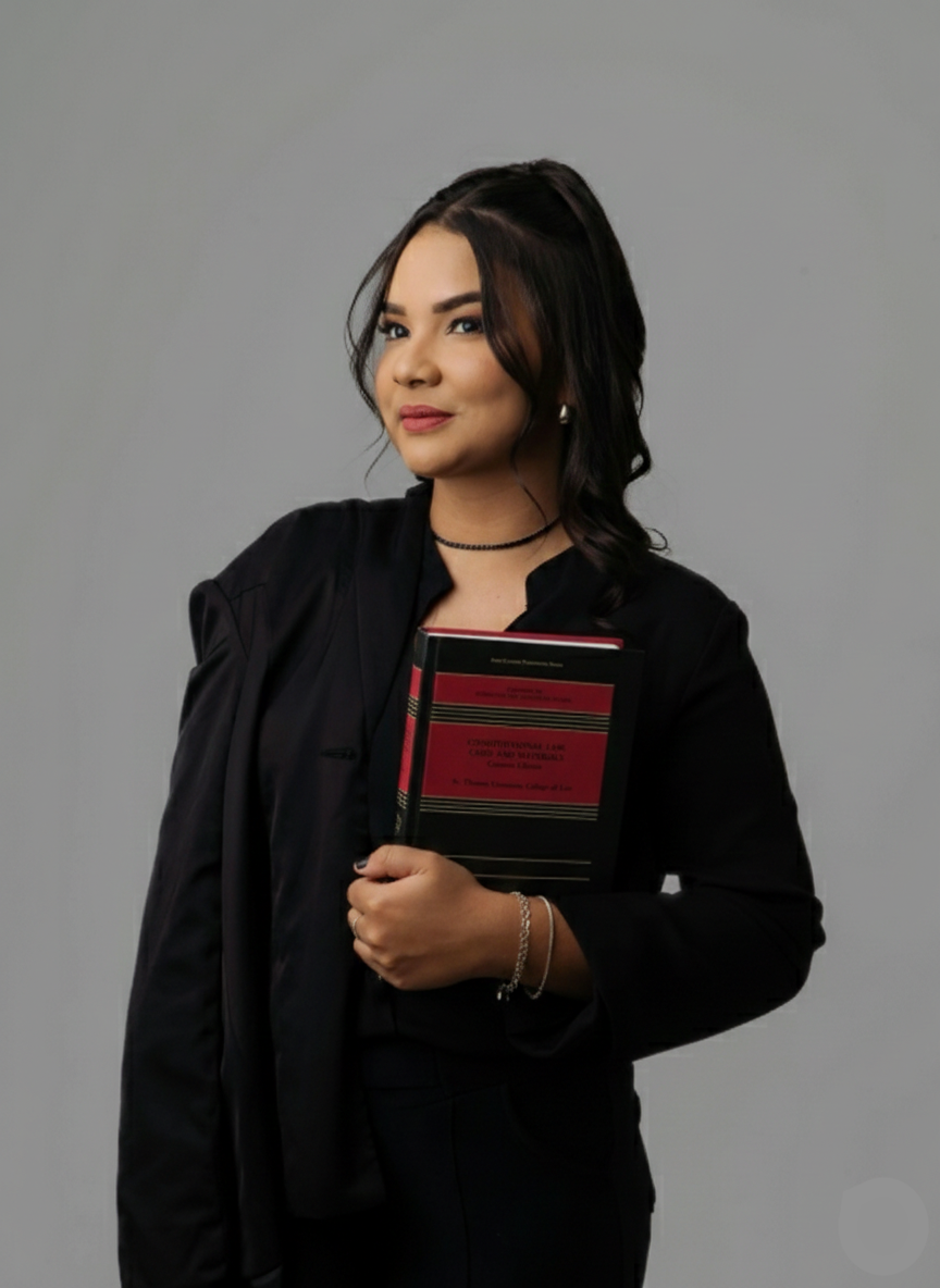 Woman in black outfit holding a patterned notebook against a gray studio background