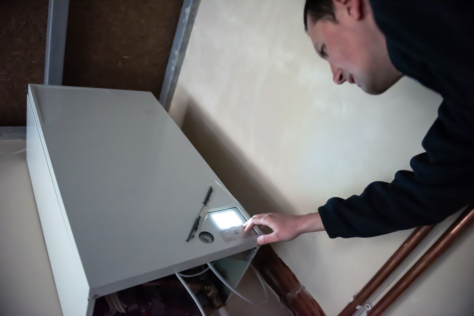 A man in a black sweater is opening a white box