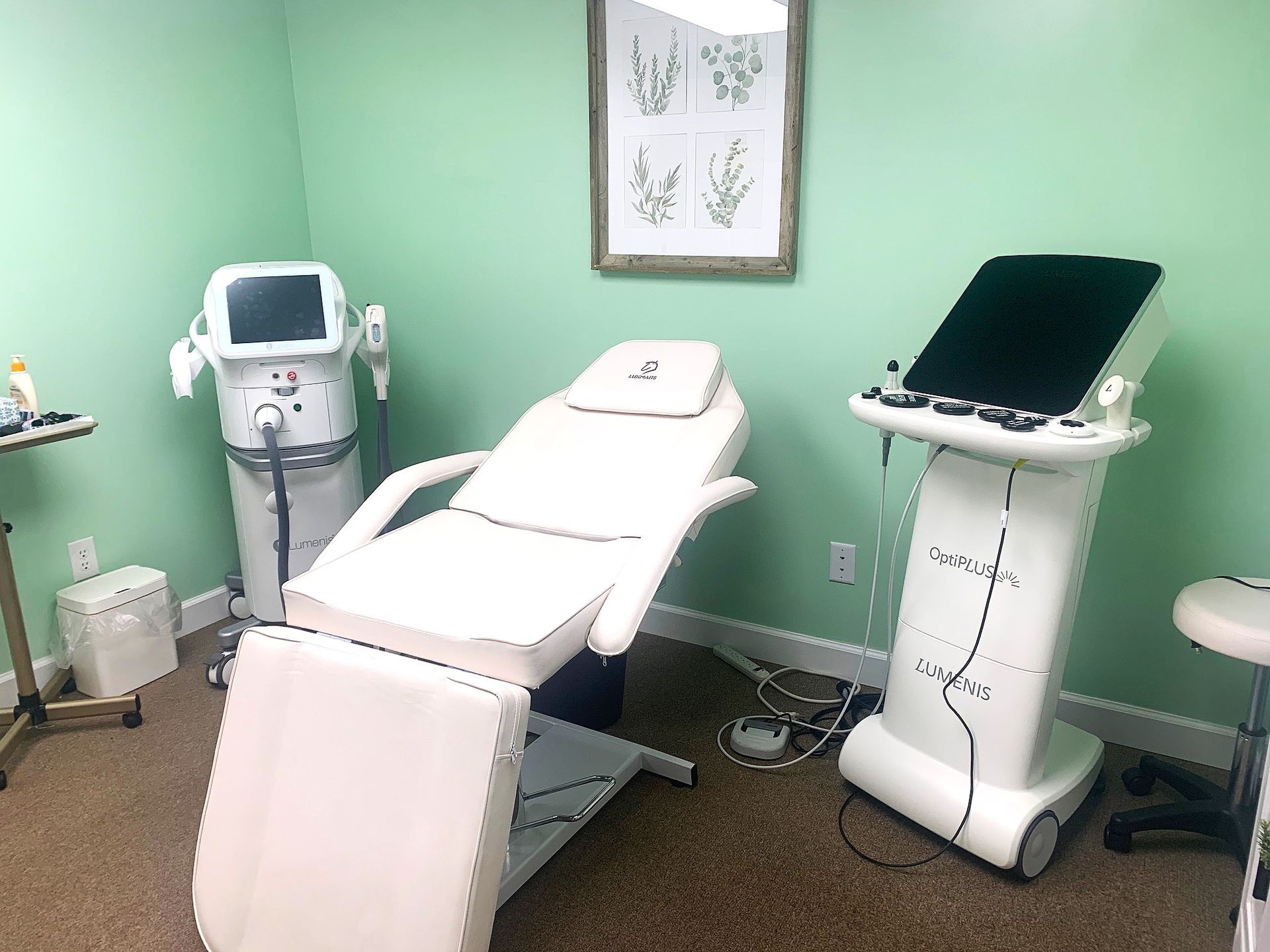 Medical treatment room with two exam beds, a monitor, and green walls