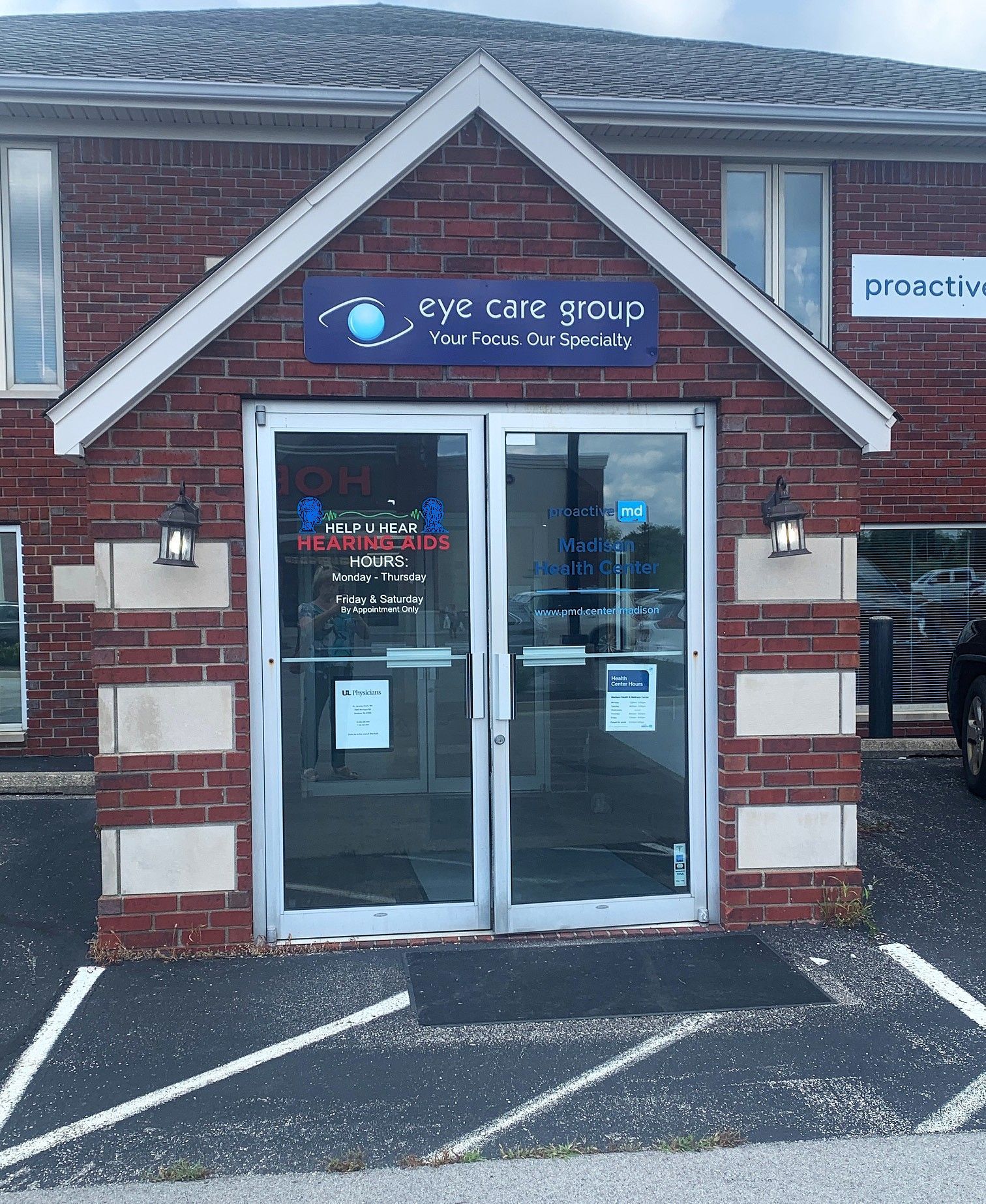 Storefront entrance to Eye Care 3000 in a brick building, with glass double doors and a parking lot outside.