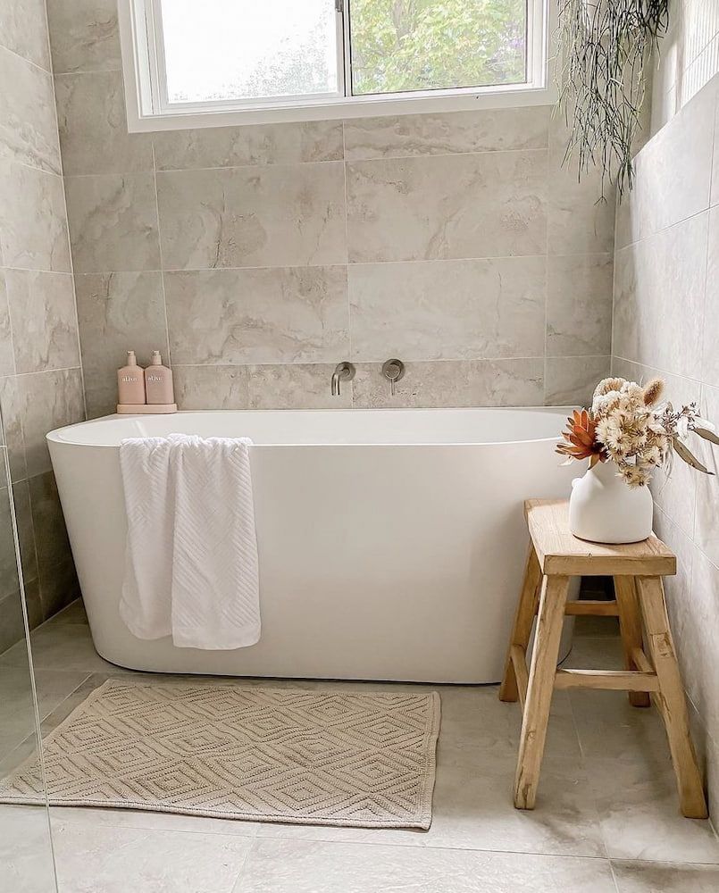 A Bathroom With A Bathtub And A Wooden Stool — Corrimal Ceramic Tiles Pty Ltd in Corrimal, NSW