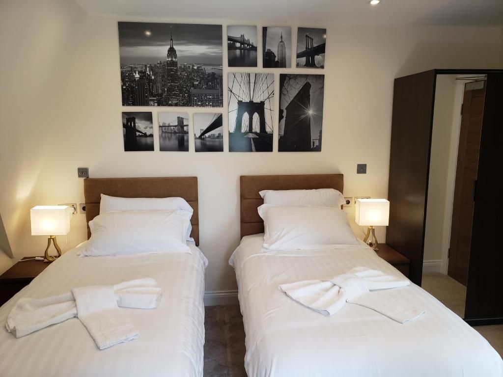 A bedroom with two beds and a collage of pictures on the wall