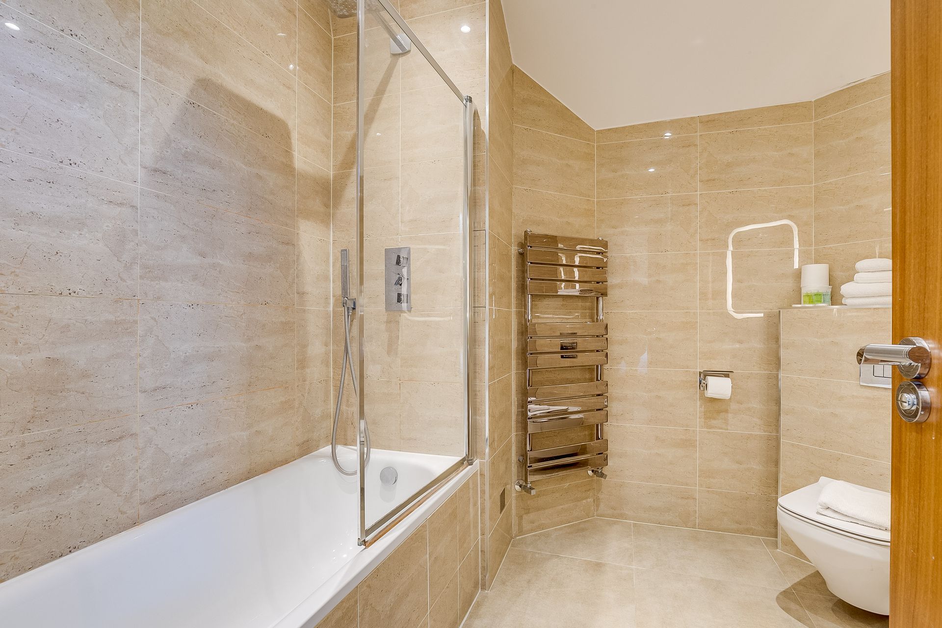 A bathroom with a bathtub , toilet and shower.