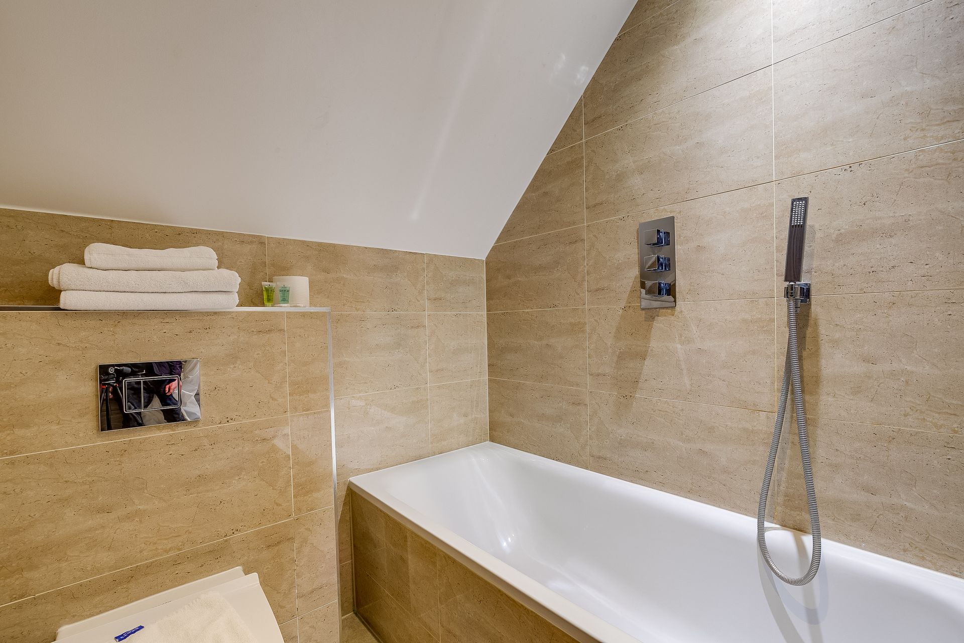 A bathroom with a bathtub , toilet and shower.