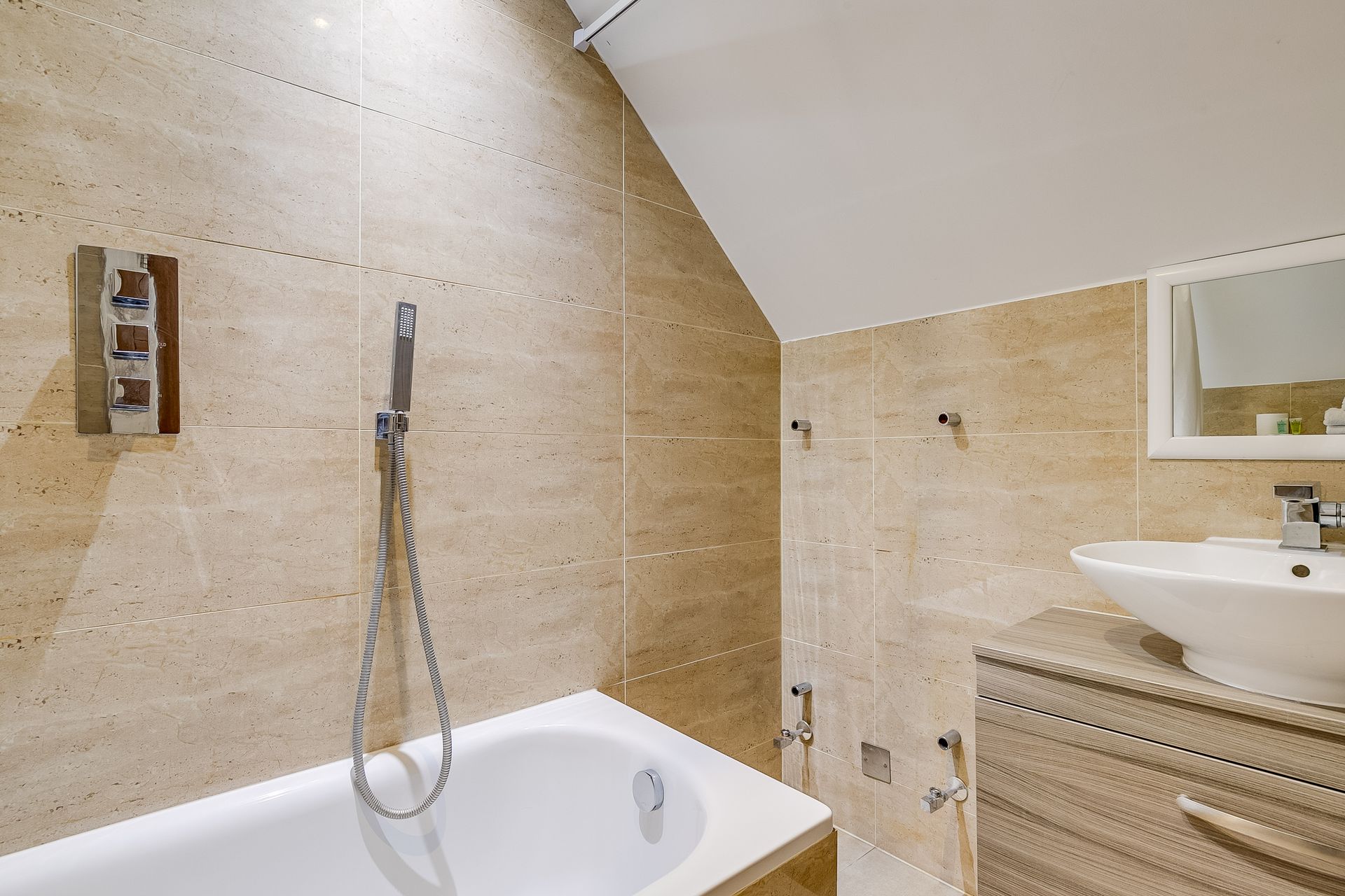 A bathroom with a bathtub , sink and shower.