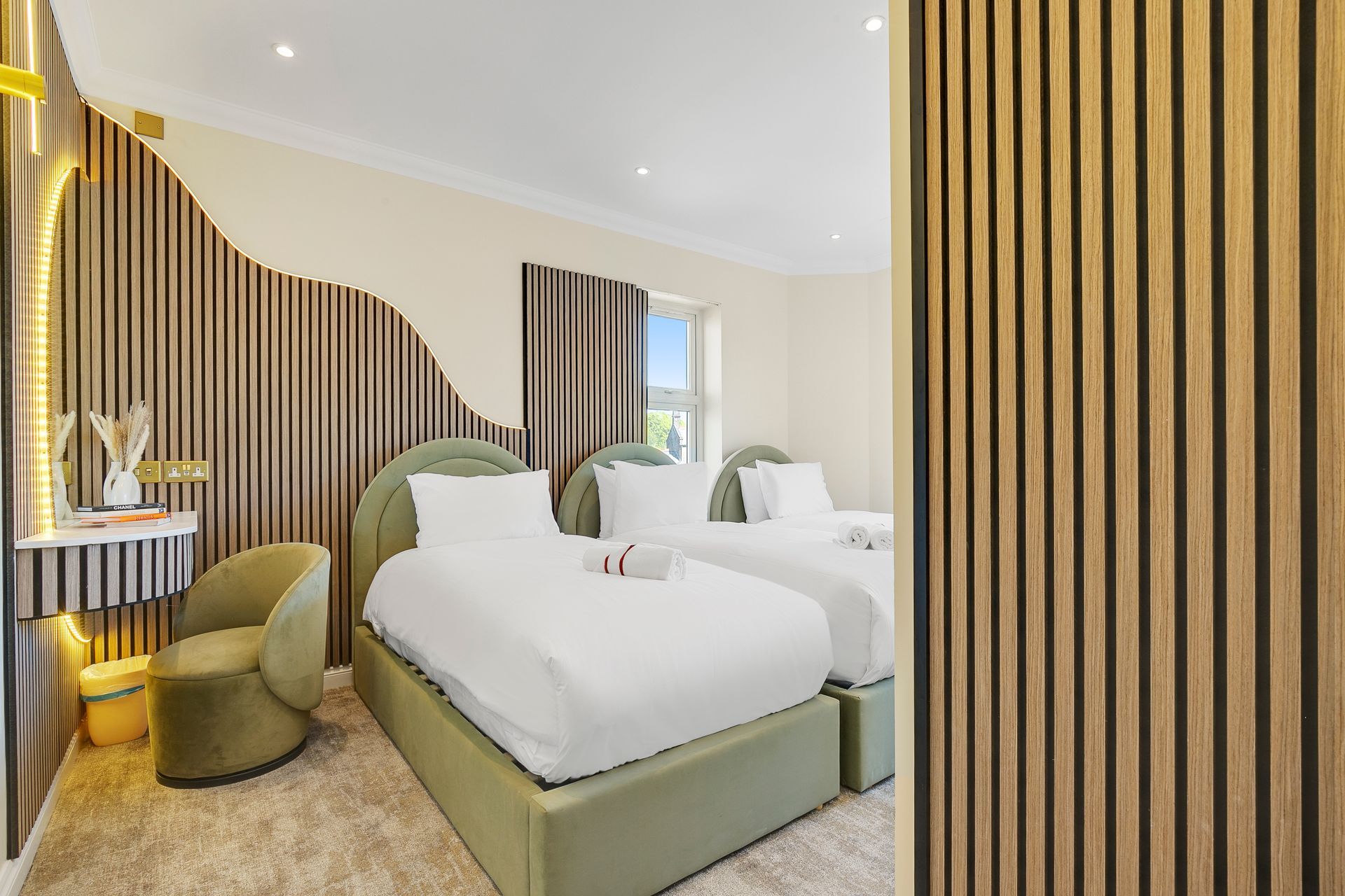 A hotel room with two beds and a chair.