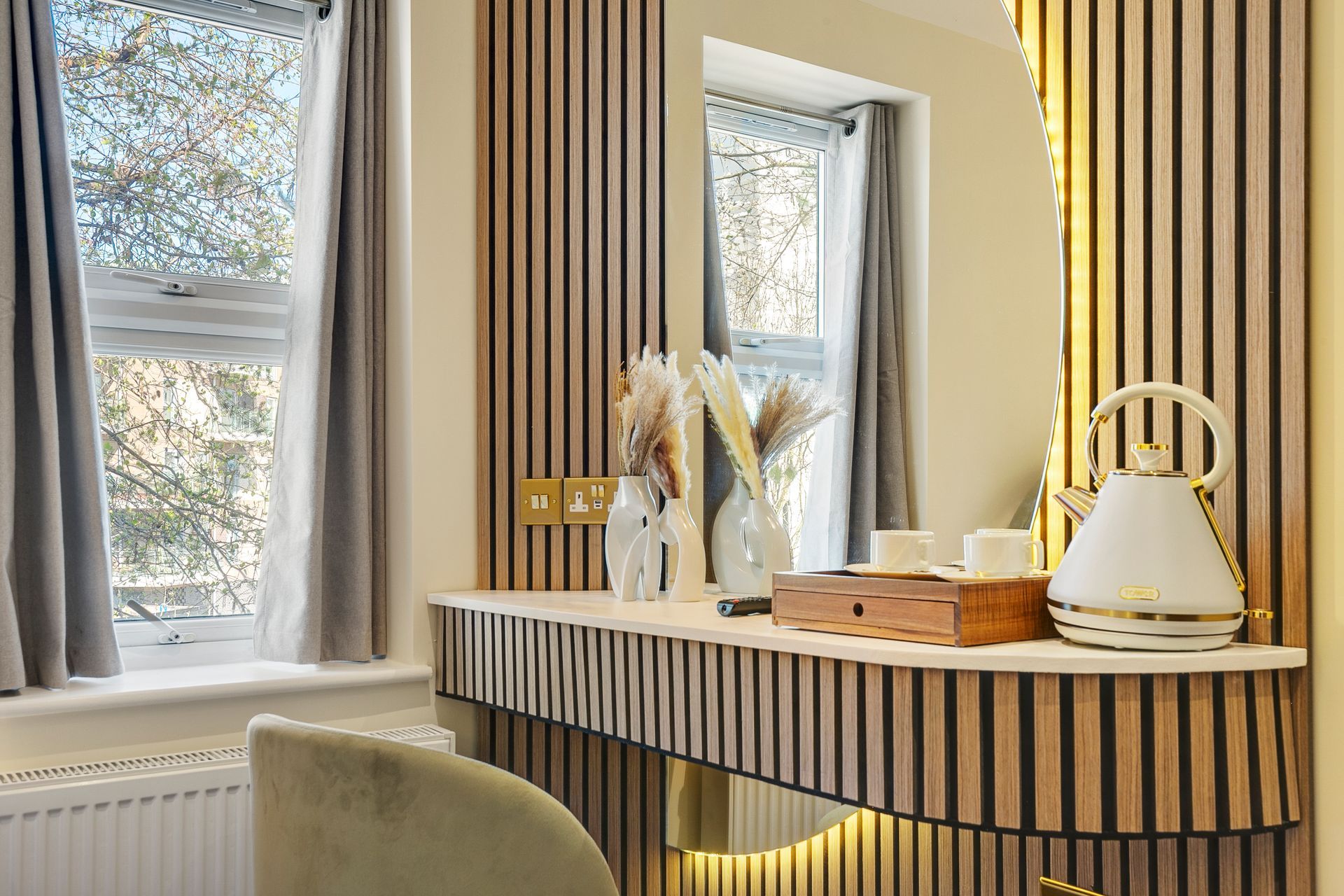 There is a dressing table with a mirror and a chair in the room.