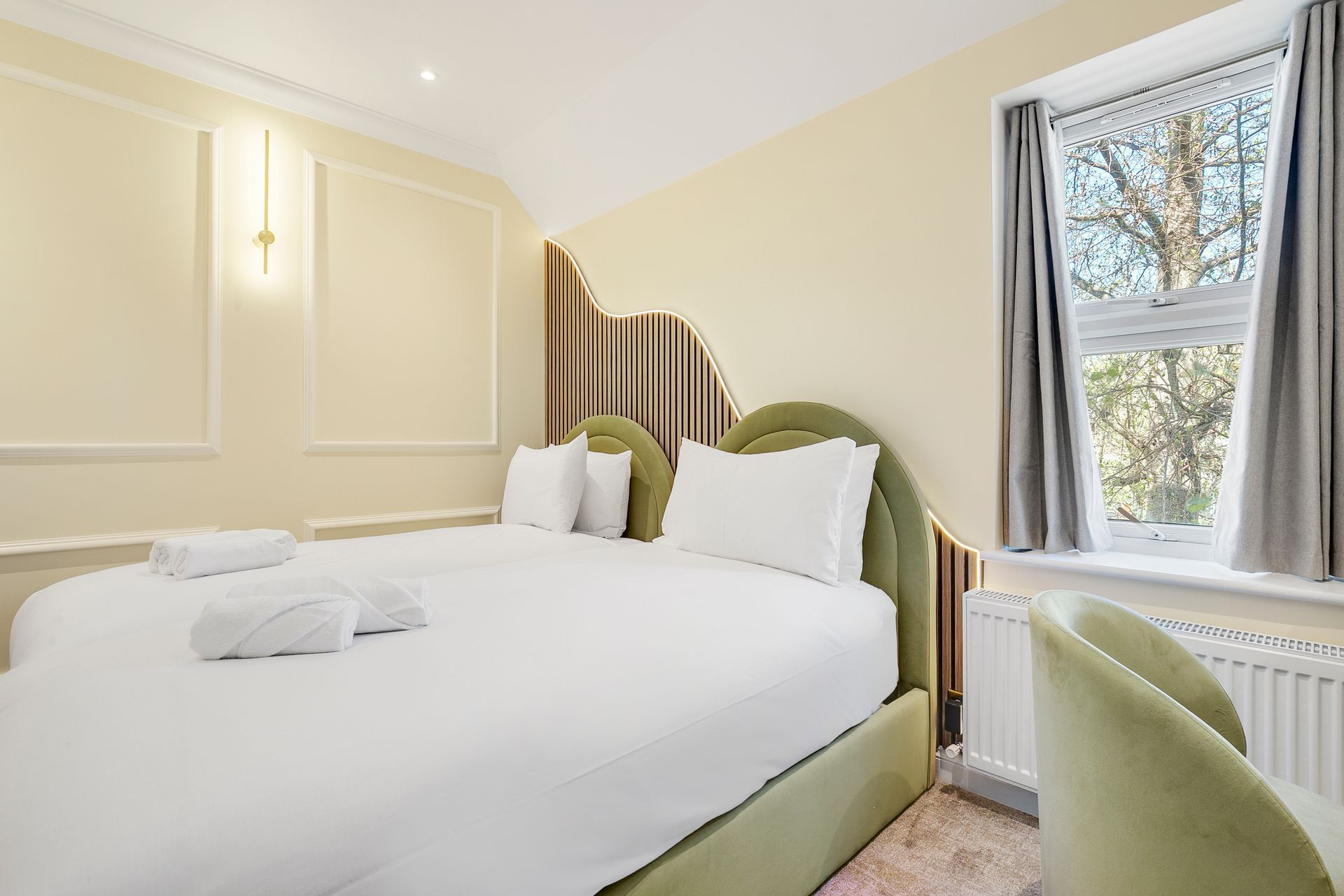 A hotel room with a king size bed and a window.