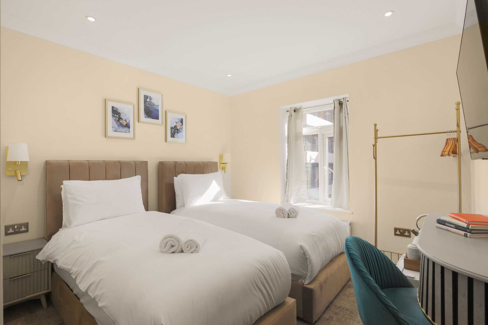 A hotel room with two beds , a desk and a chair.
