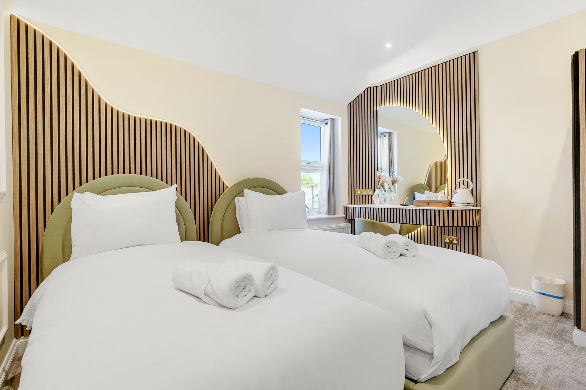 A hotel room with two beds and a mirror.