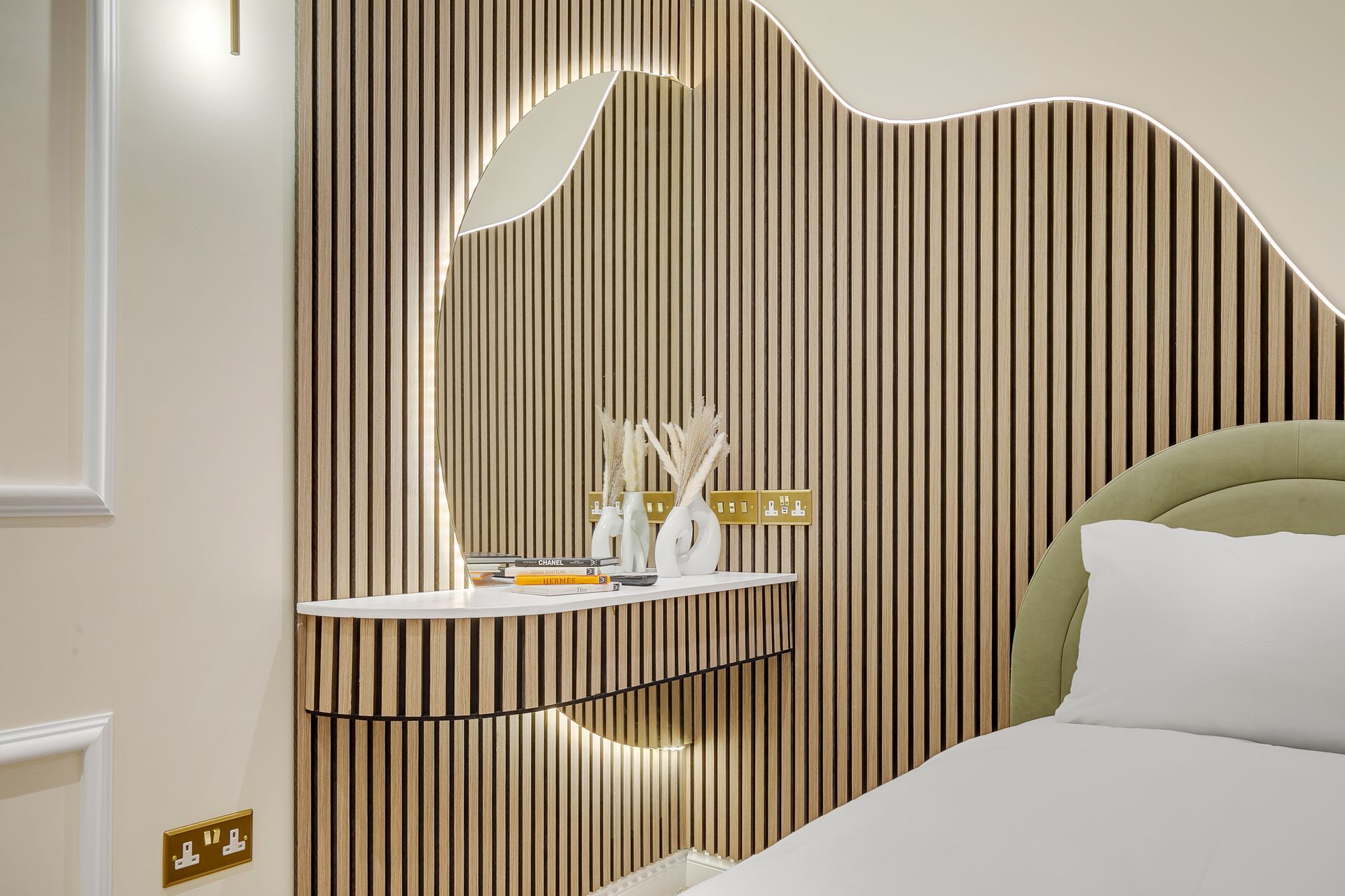 A bedroom with a bed , dresser , mirror and striped wall.