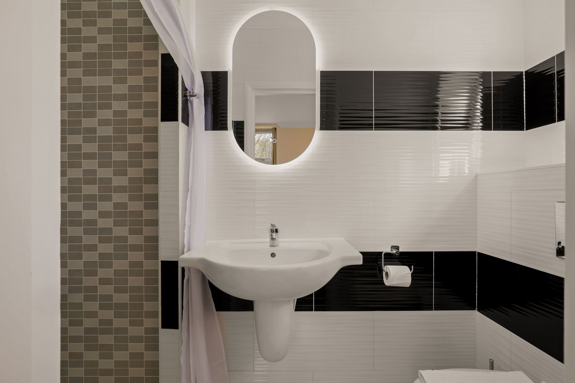 A bathroom with a sink , toilet and mirror.