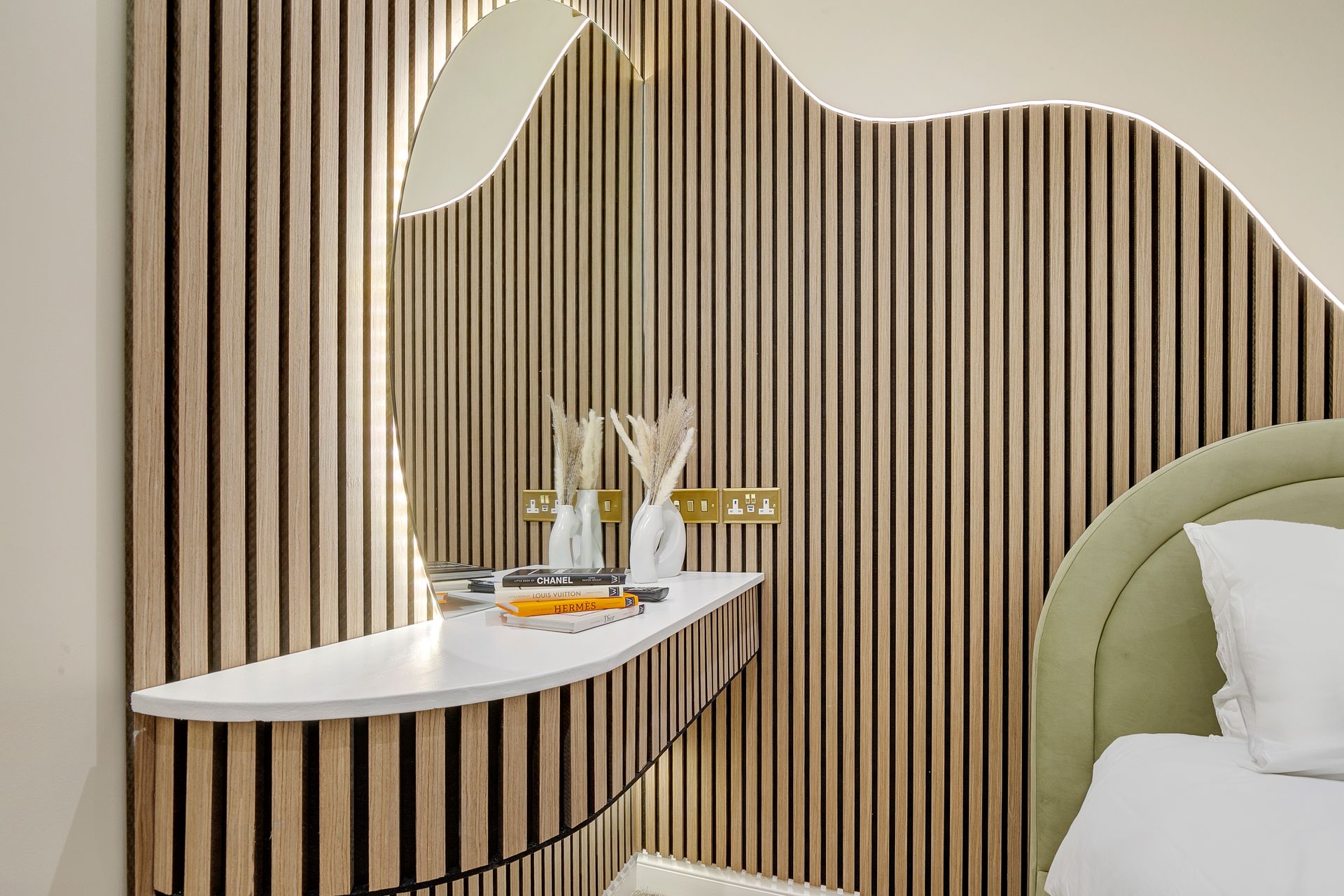 A bedroom with a bed , a mirror and a wooden wall.