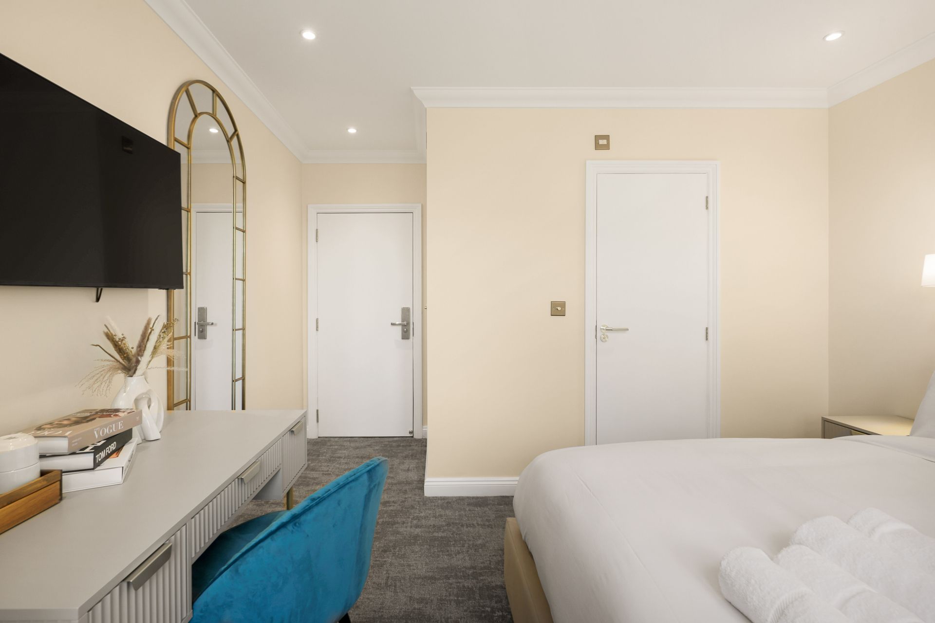 A hotel room with a bed , desk , chair and television.