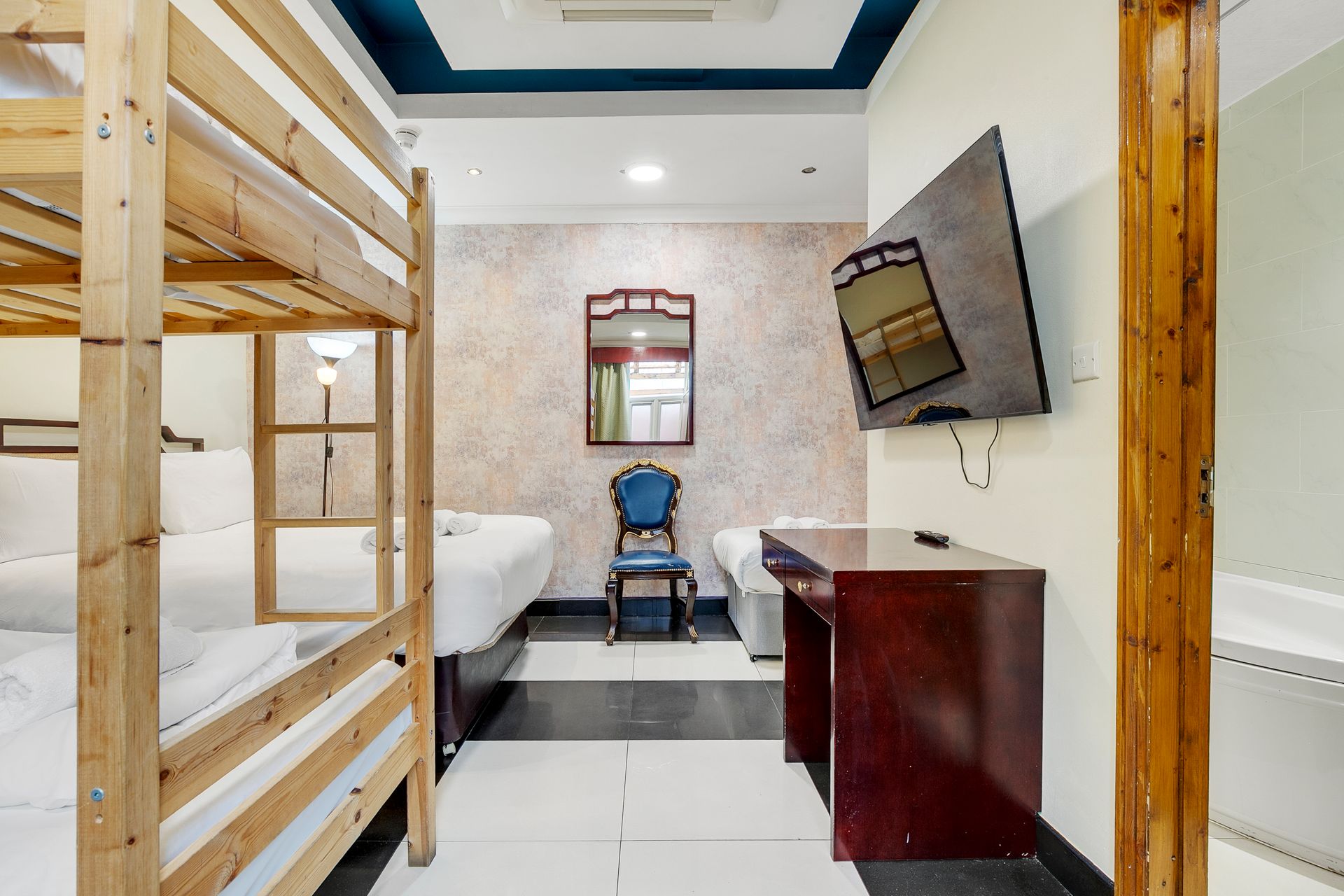 A hotel room with bunk beds and a flat screen tv