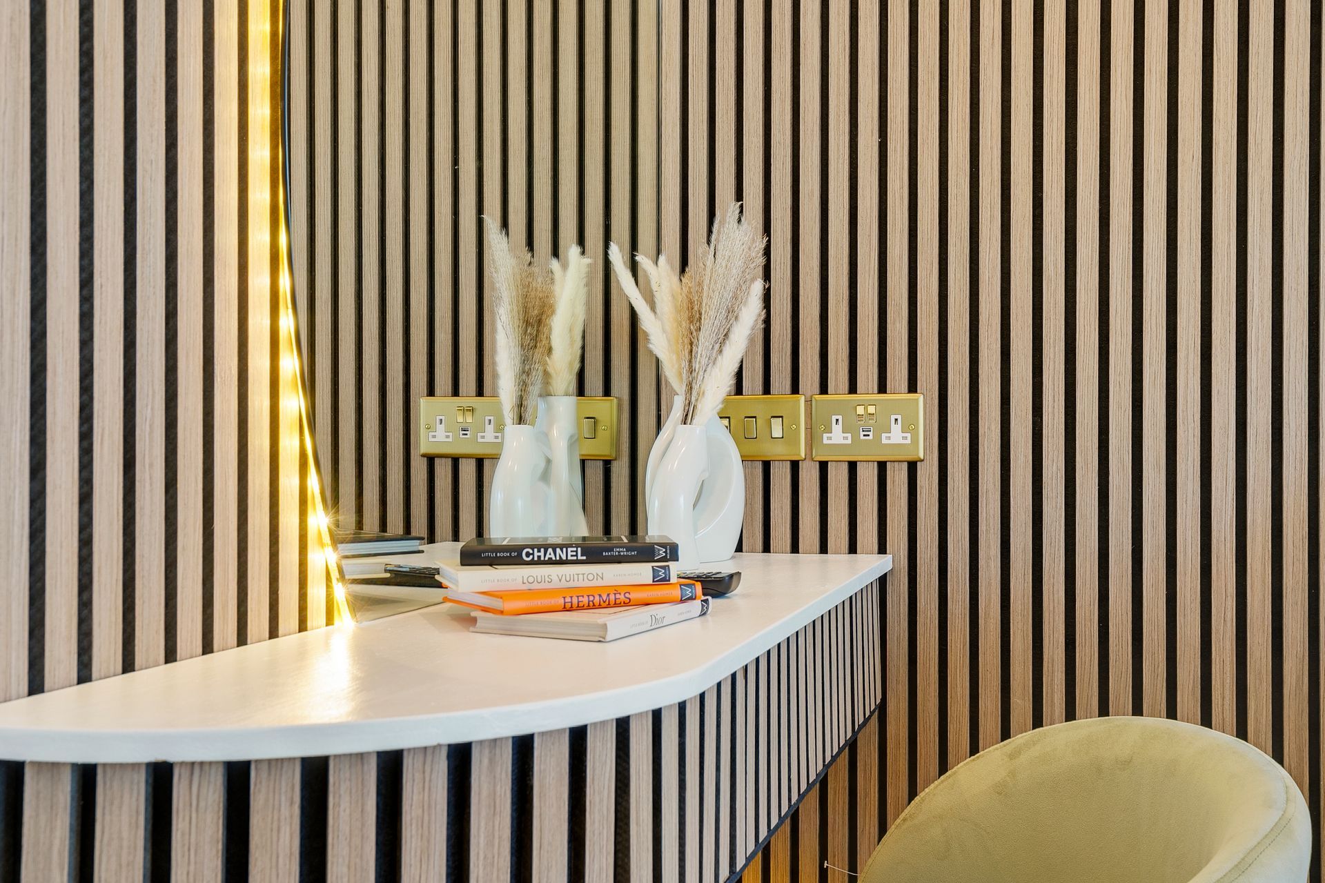 A wooden wall with a desk and chair in front of it.