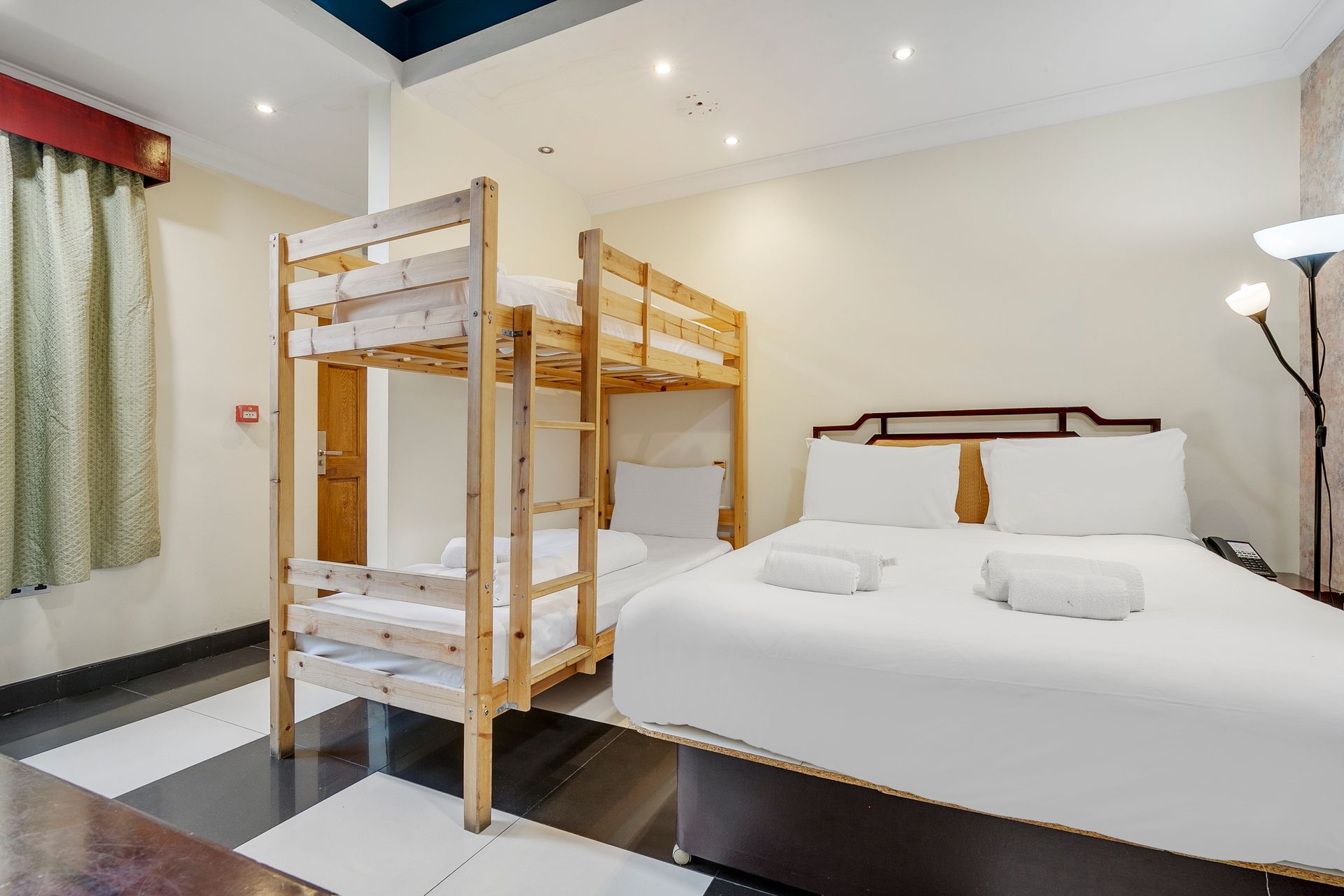 A hotel room with two beds and two bunk beds.