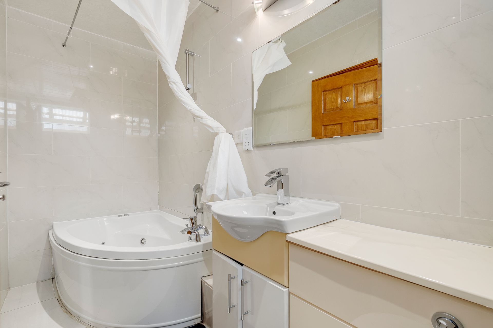 A bathroom with a jacuzzi tub , sink and mirror.
