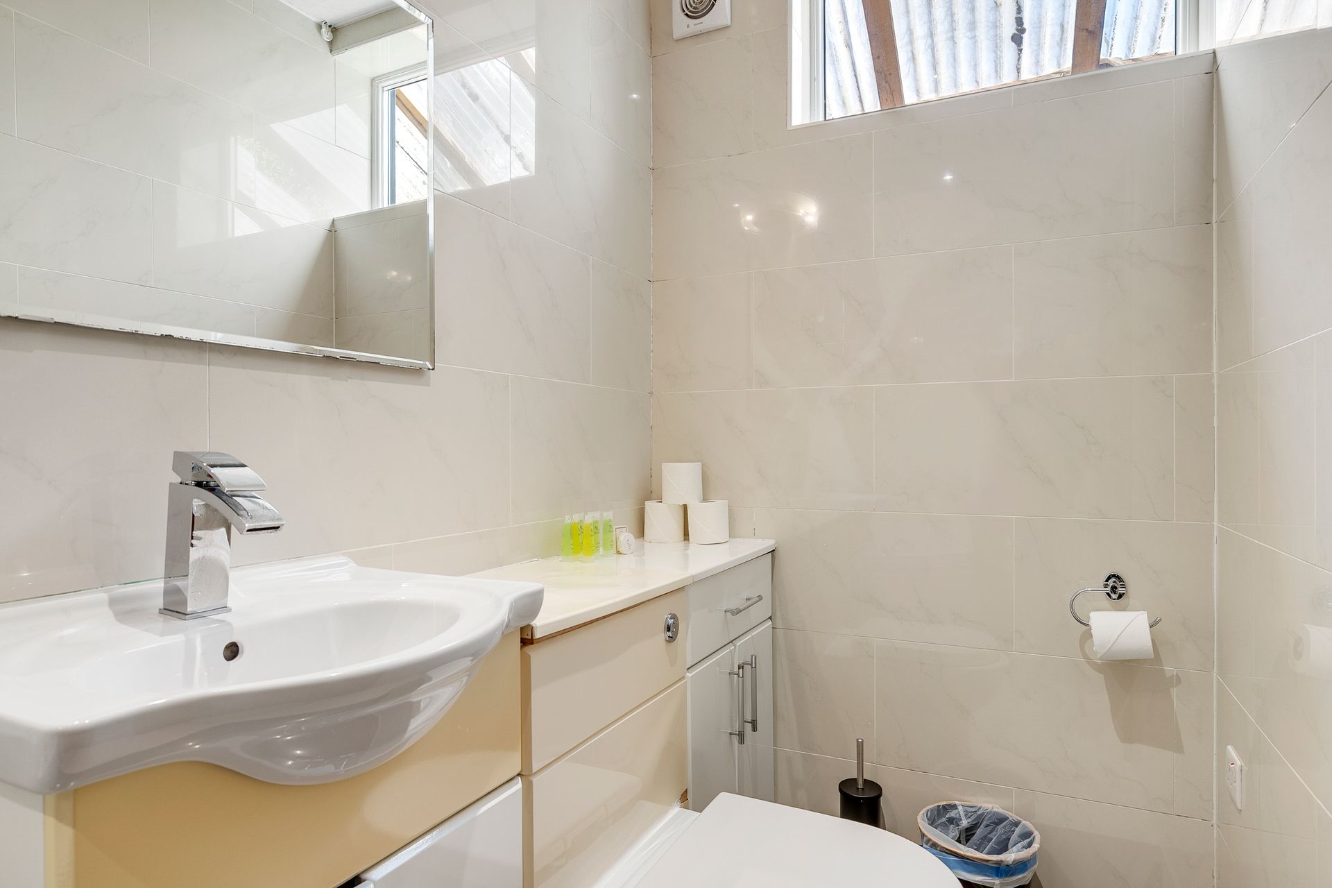 A bathroom with a sink , toilet and mirror.