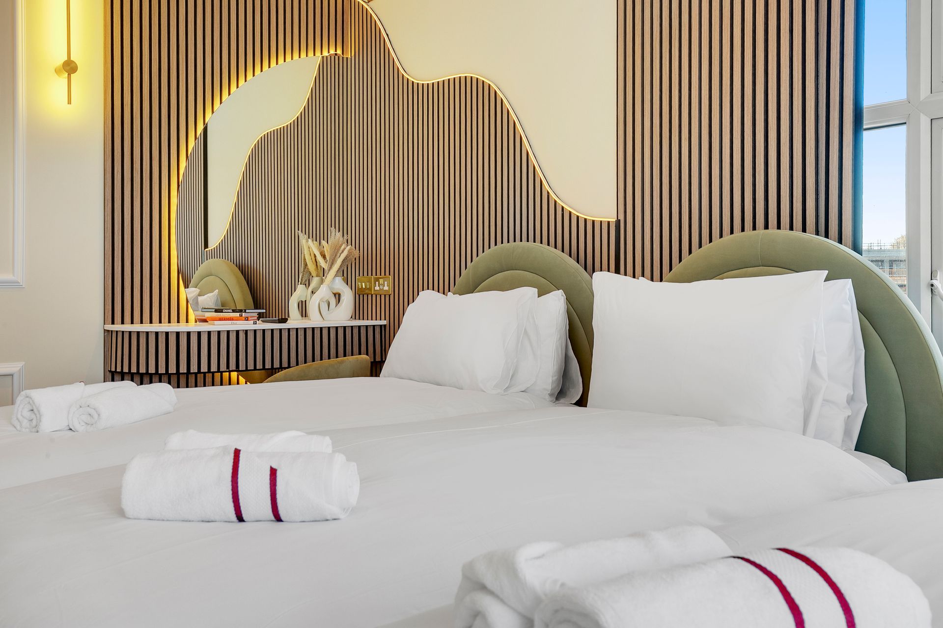 A hotel room with a bed , towels and a mirror.