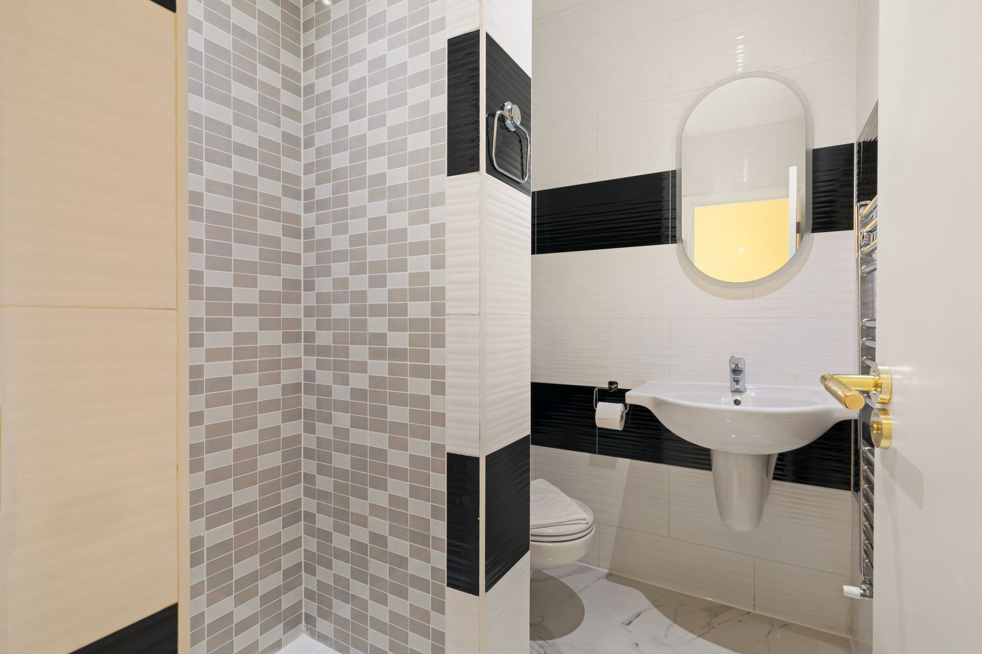 A bathroom with a sink , toilet , shower and mirror.