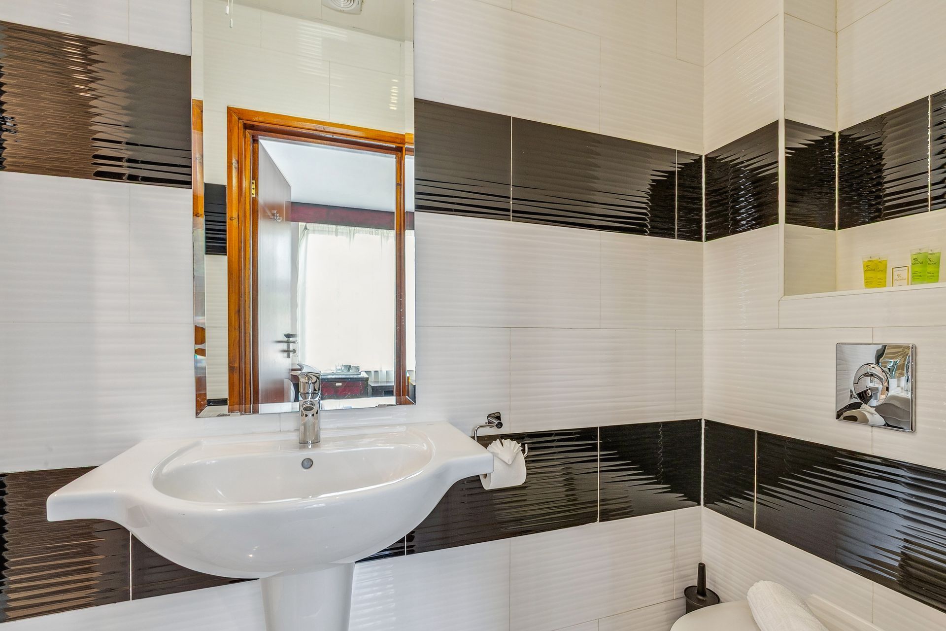 A bathroom with a sink , toilet and mirror