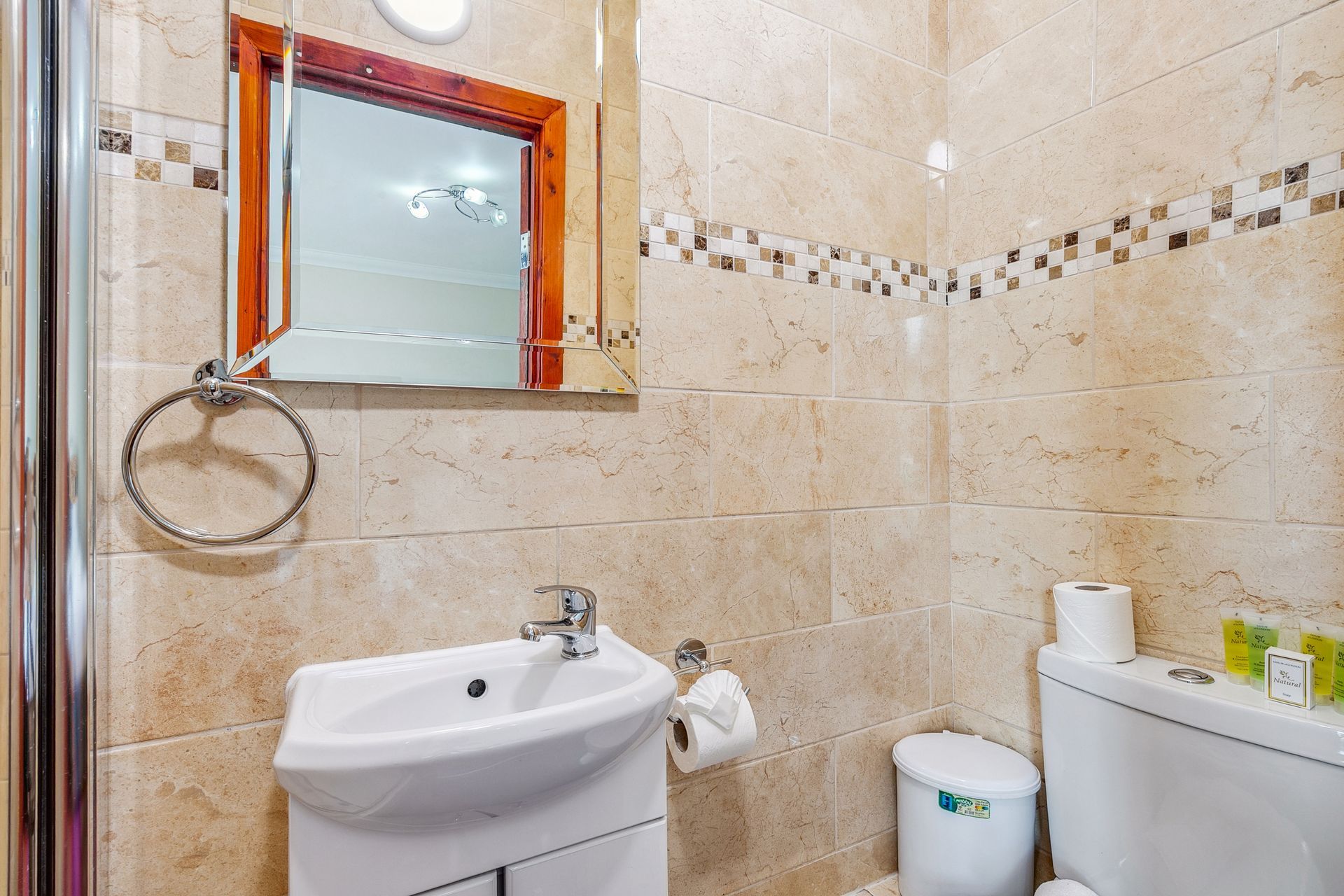 A bathroom with a sink , toilet and mirror.