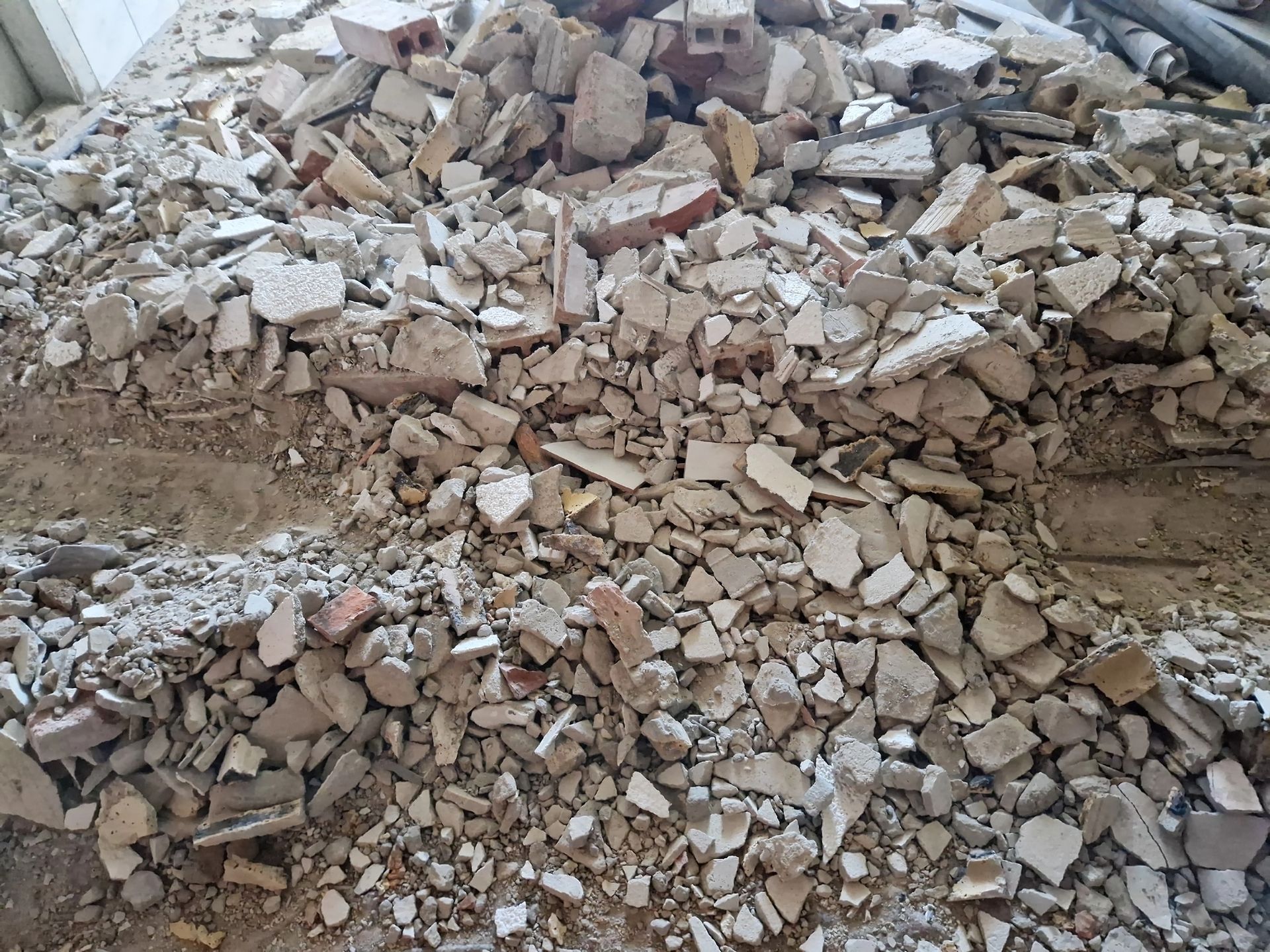 Cumulo di mattoni rotti, macerie e detriti provenienti da un muro o un edificio demolito.