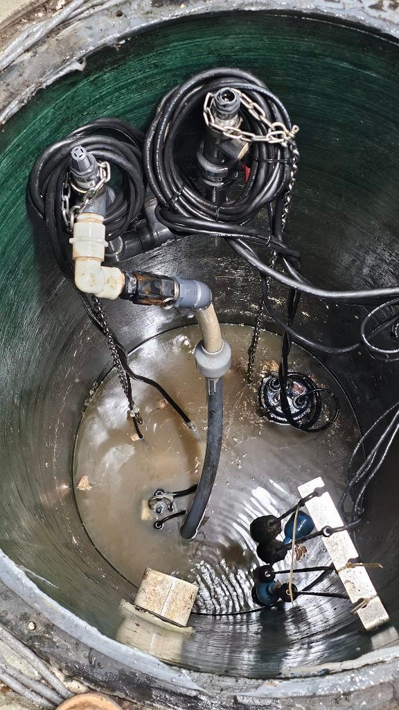 Inside a green utility vault, pipes, cables, and electrical components are visible.