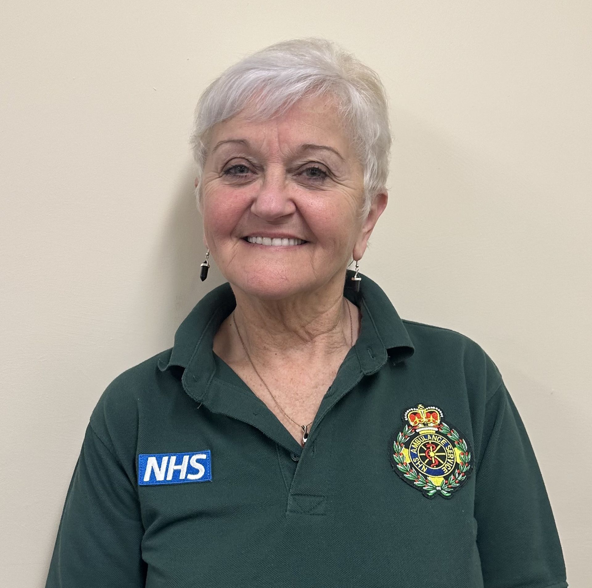 A photo of Kate who has short white hair and is in ambulance uniform.