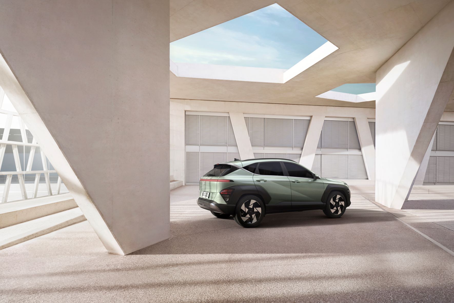 A green suv is parked in a parking lot next to a building. Kona N Line Electric